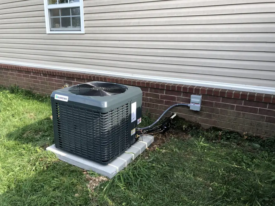 A newly installed outdoor AC condenser on a pad beside a home
