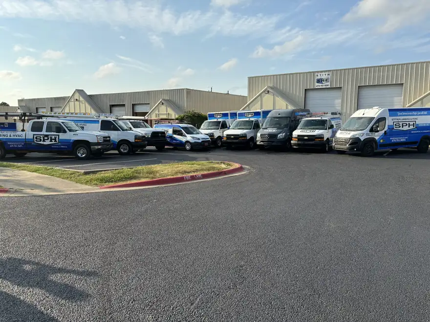The Stith Plumbing & HVAC fleet of branded service vans lined up outside the Springdale shop