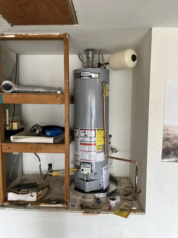 Gas water heater and new copper piping inside a built-in utility cabinet